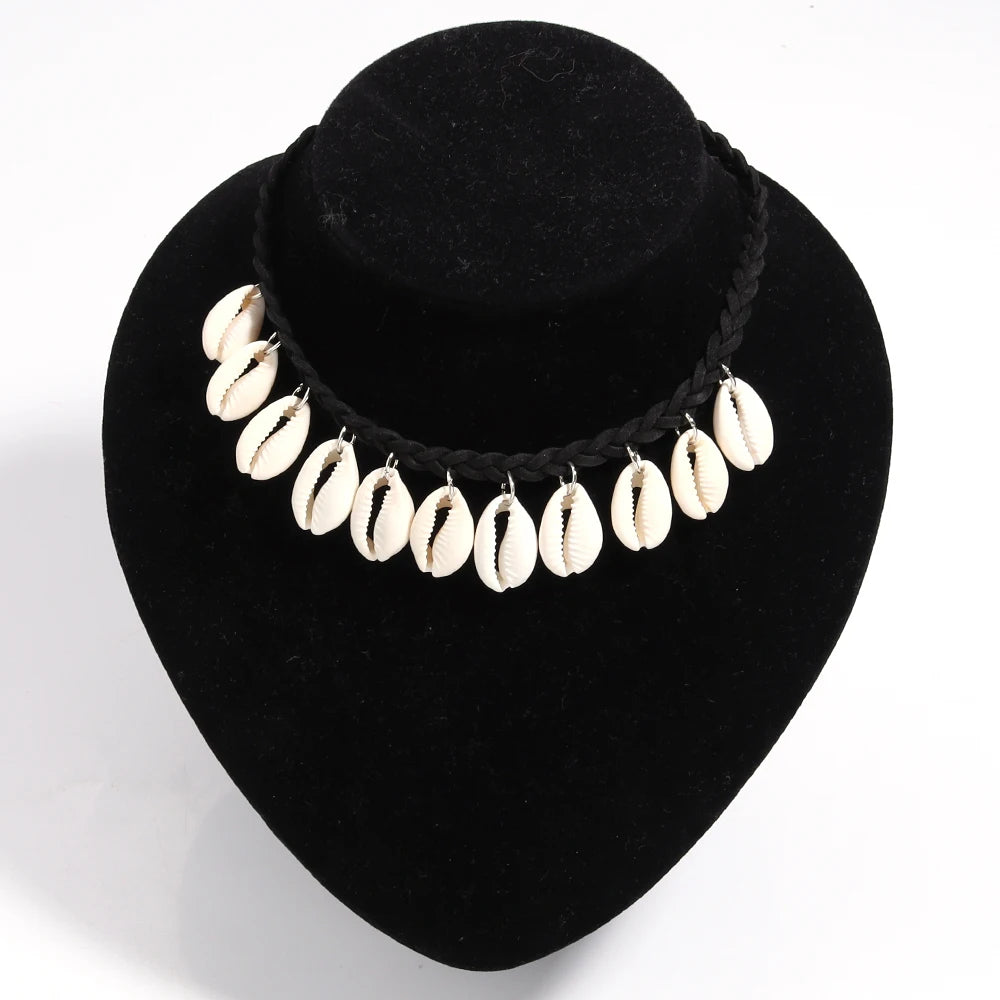 Necklace with cowrie shells on a black velvet stand against a white background