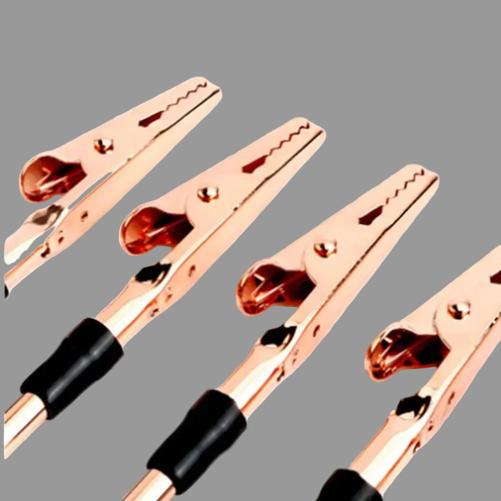 Set of four rose gold alligator clips with black insulated ends on a white background