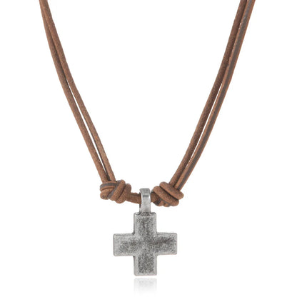 A silver cross pendant necklace on a brown double-strand cord, shown against a plain white background.