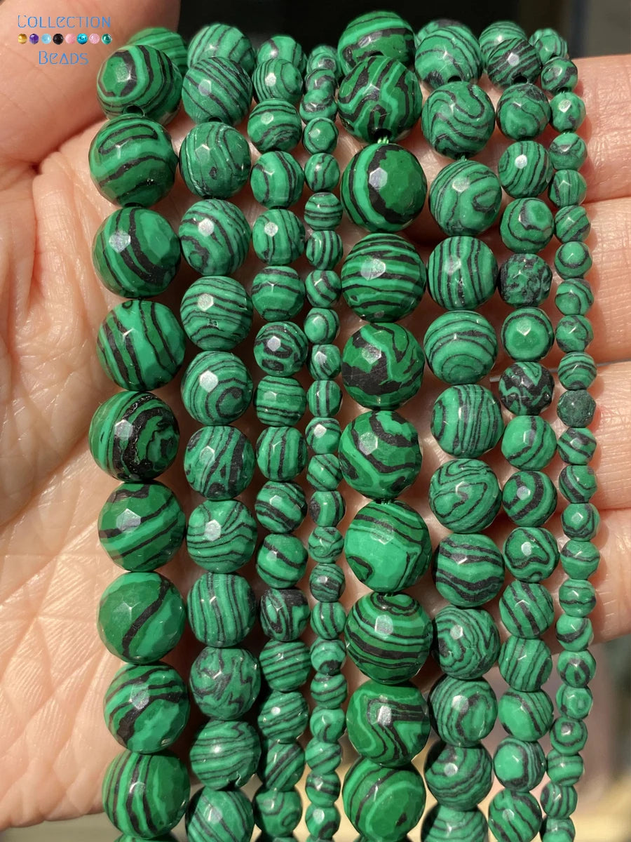 Multiple strands of green malachite beads with natural swirling patterns, held in a person's hand.