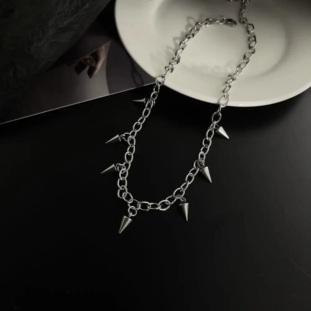 Silver chain necklace with spikes on a dark surface