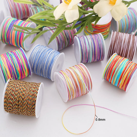 Multiple spools of thin braided thread or cord in assorted colors arranged on a white surface, with a single strand shown in the foreground and a small '0.8mm' size marker.