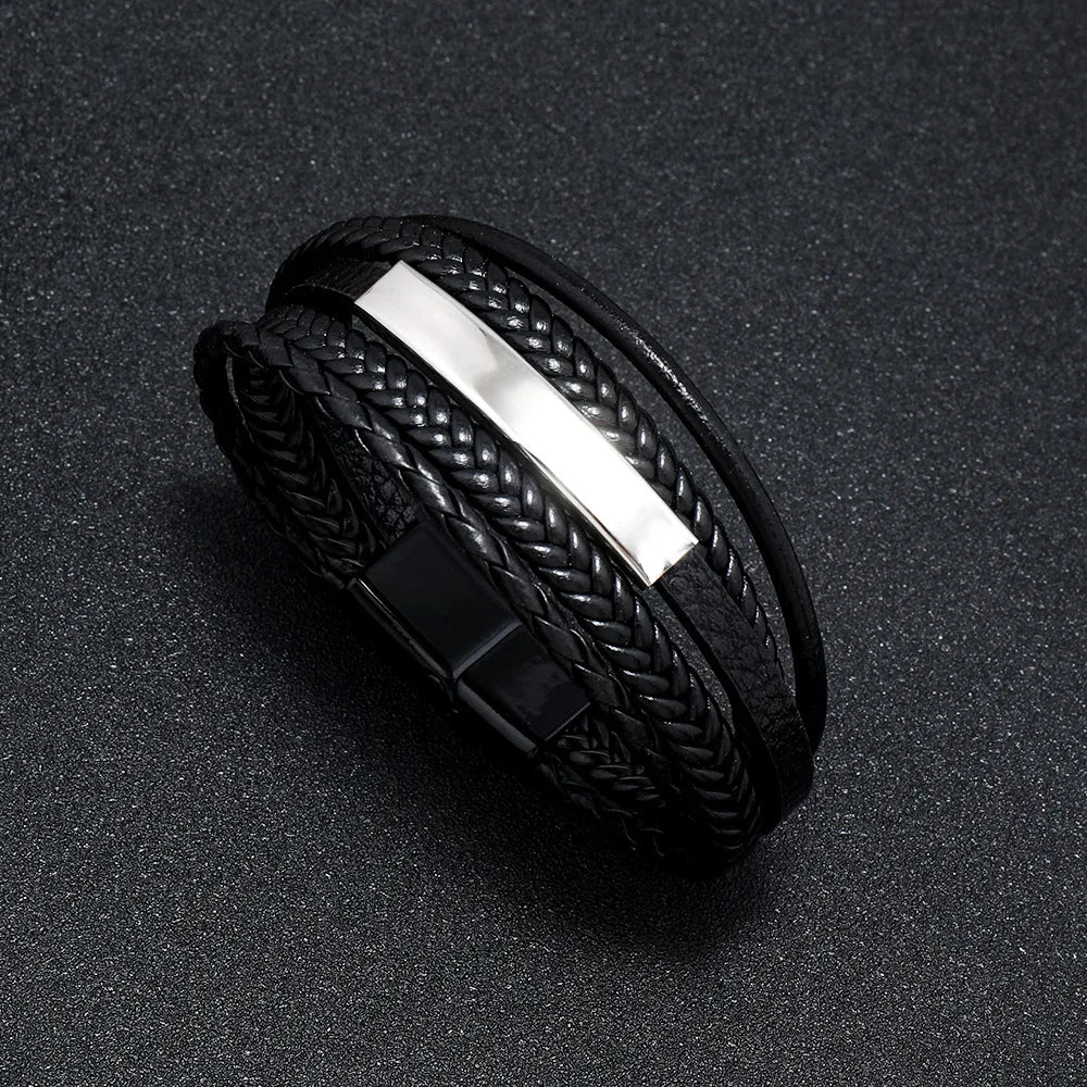 Black braided bracelet with a metallic strip on a dark surface