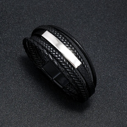 Black braided bracelet with a metallic strip on a dark surface