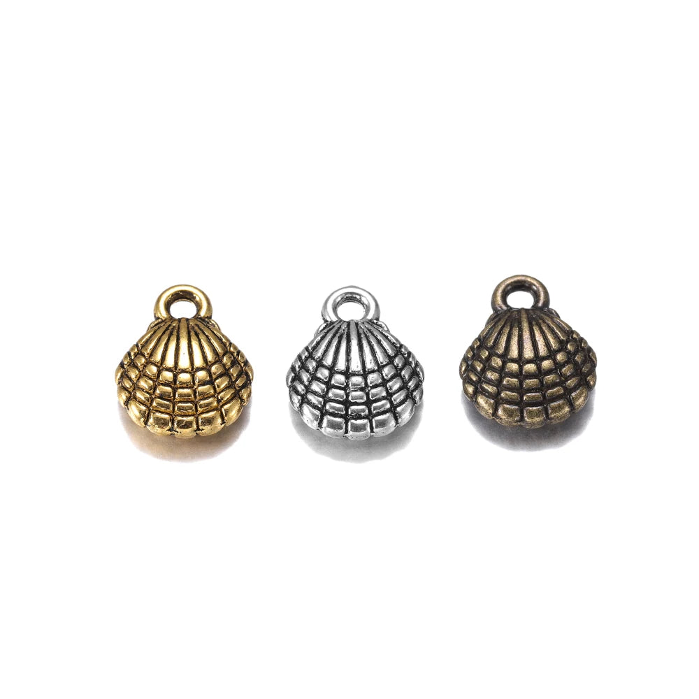Three small shell-shaped jewelry charms in antique gold, silver, and bronze finishes, arranged horizontally on a plain white background.