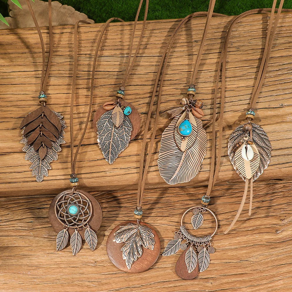 Collection of feather-themed necklaces on a wooden surface