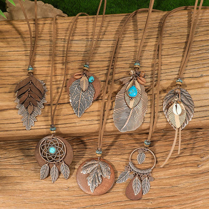 Collection of feather-themed necklaces on a wooden surface