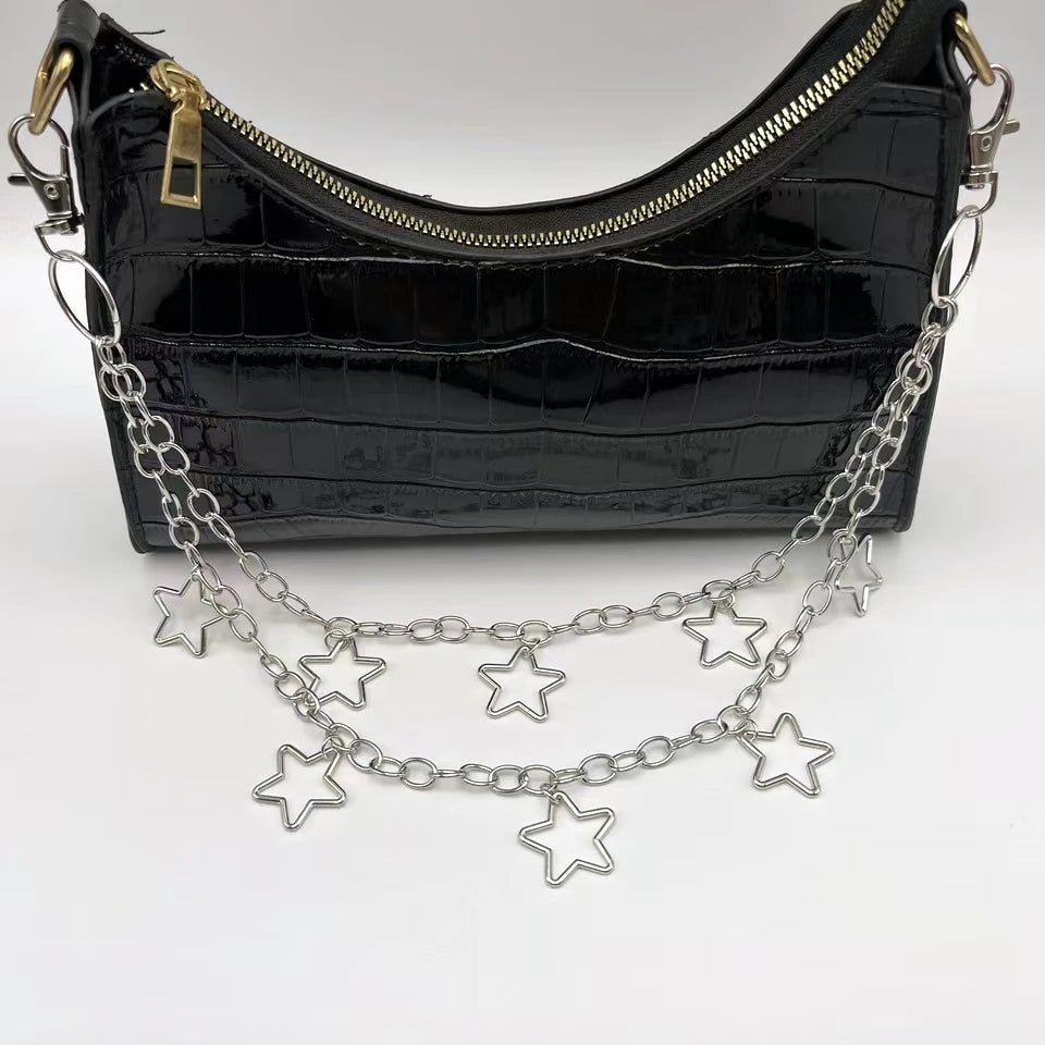 Black handbag with a chain strap featuring star charms on a white background