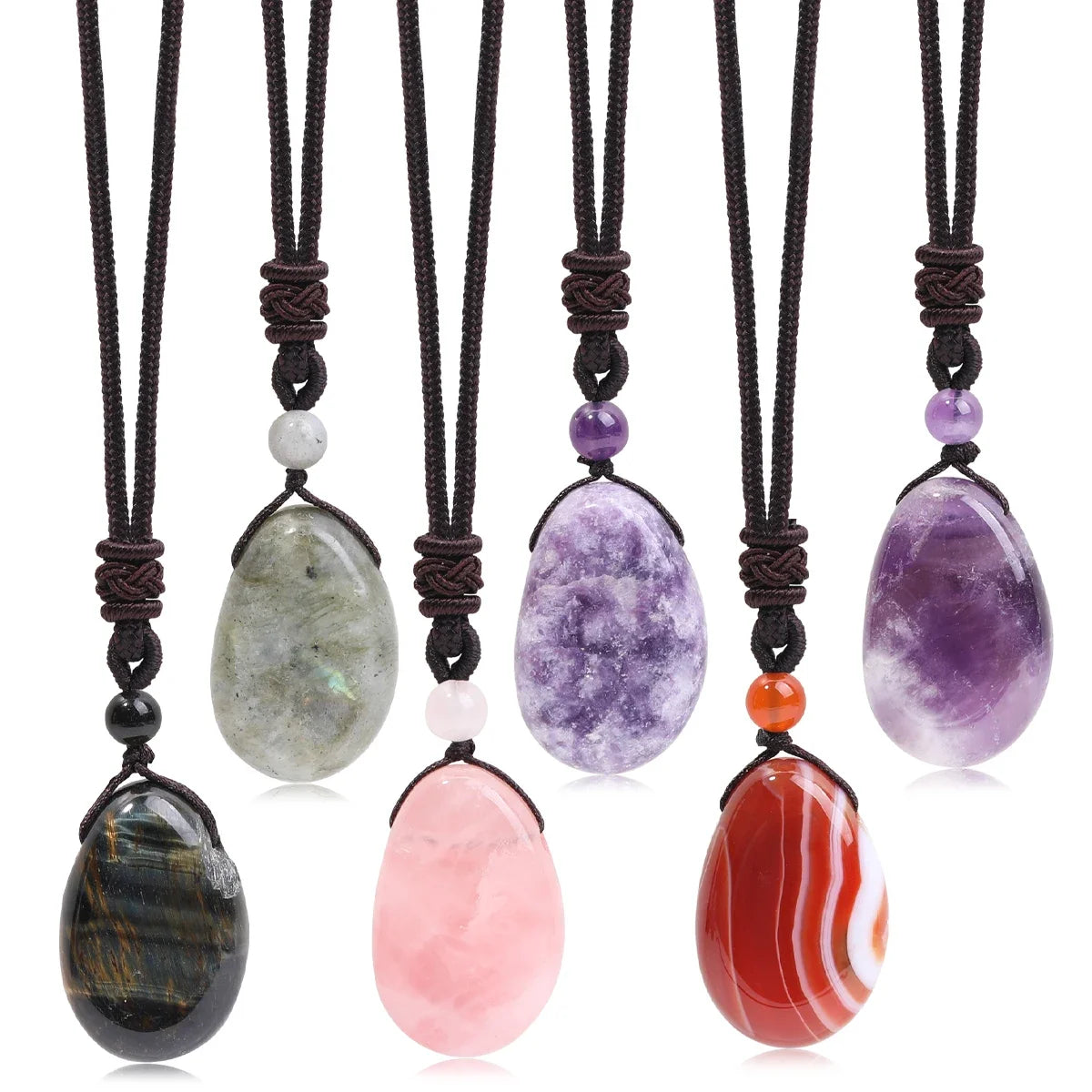 Set of six stone pendants on black cords with a white background