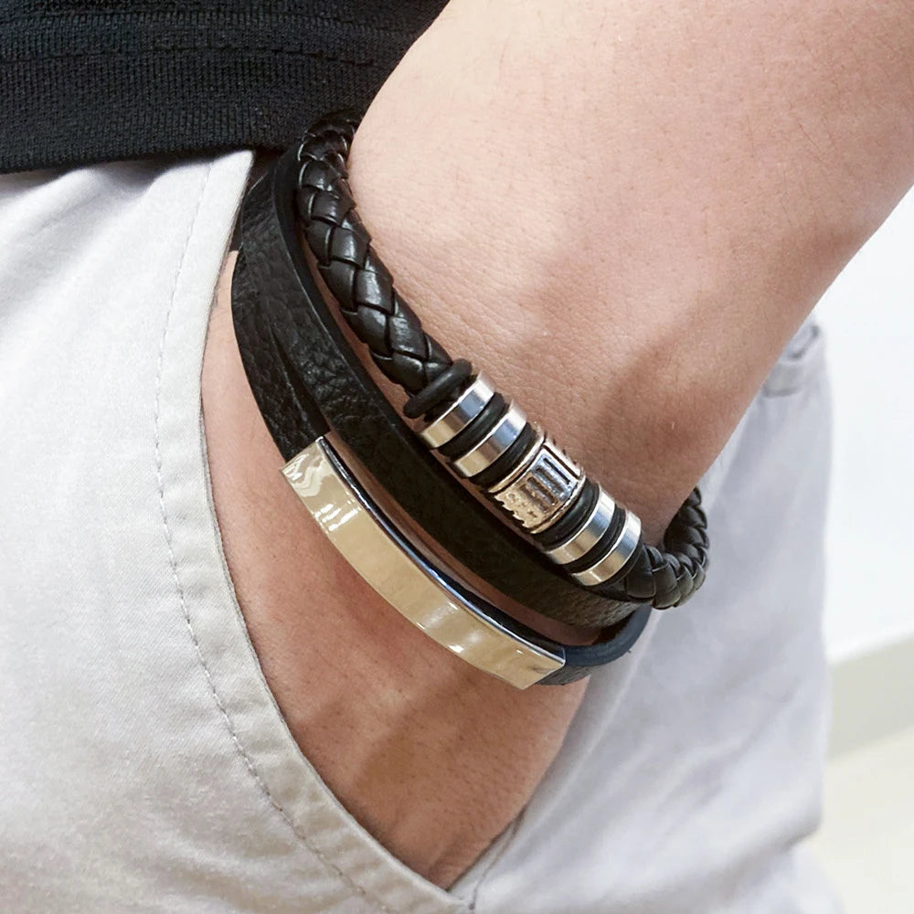 Close-up of a person's wrist wearing multiple leather bracelets with metal accents.