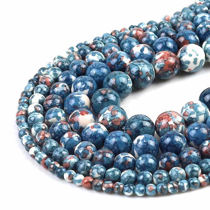 Multiple strands of round marbled beads in shades of blue, white, and terracotta red, arranged in a spiral on a white background.