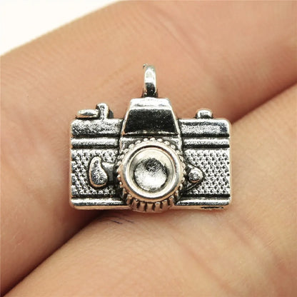 Silver camera-shaped pendant on a finger