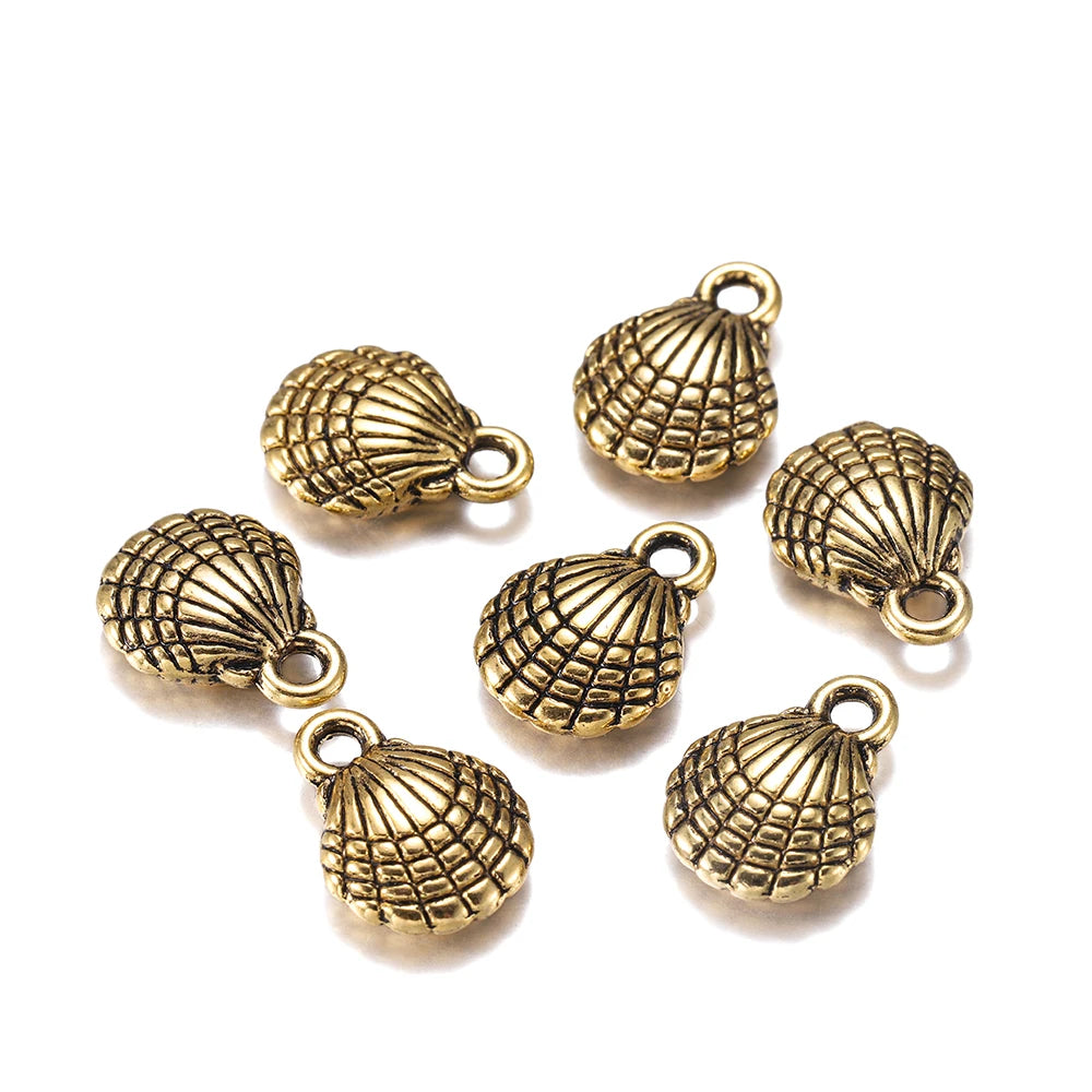 Seven antique bronze seashell jewelry charms with loop tops, arranged on a clean white background.