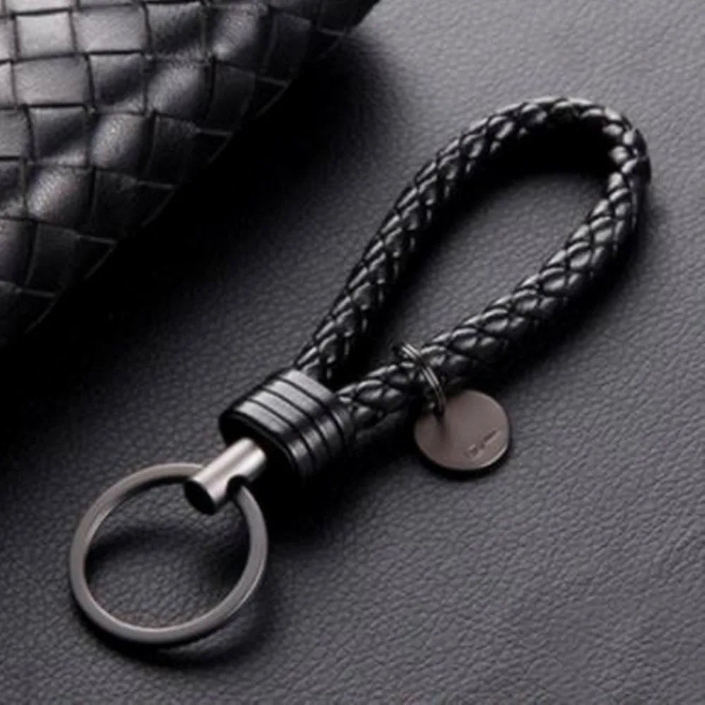 Black braided keychain on a textured gray surface