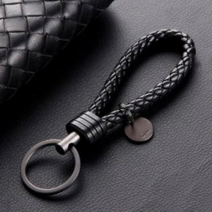 Black braided keychain on a textured gray surface