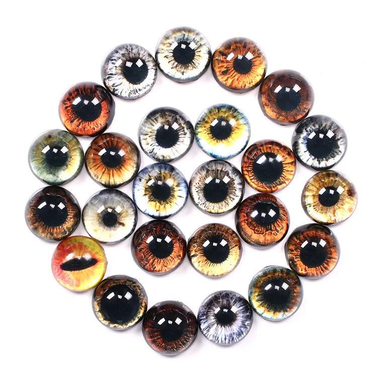 A collection of round, glossy faux-eye craft beads arranged in a circular pattern on a plain white background. The beads feature various realistic eye designs in brown, orange, green, blue, yellow, and gray tones.