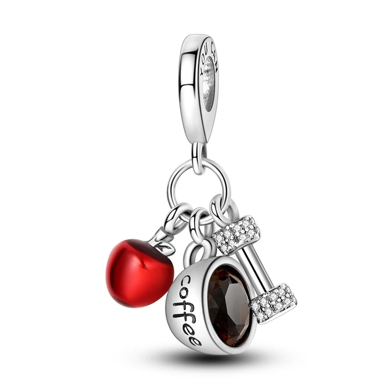 Silver charm with red heart, coffee cup, and key on a white background