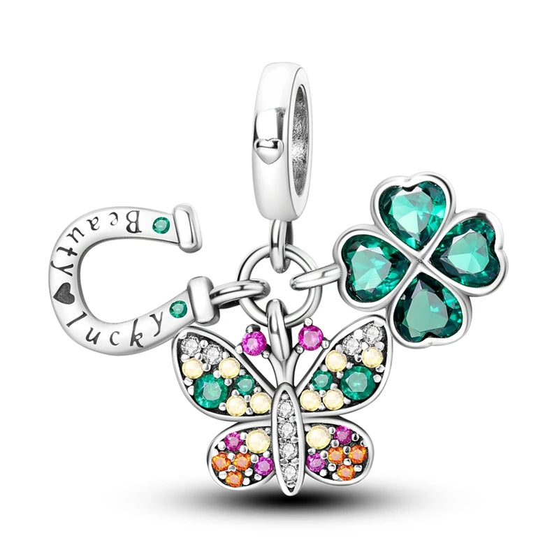 Silver charm with butterfly and four-leaf clover design on a white background