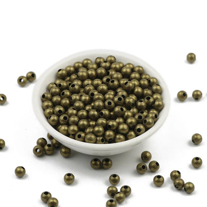 Bronze beads in a white bowl on a white background