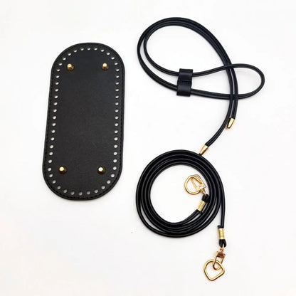 Black purse strap with gold hardware on a white background