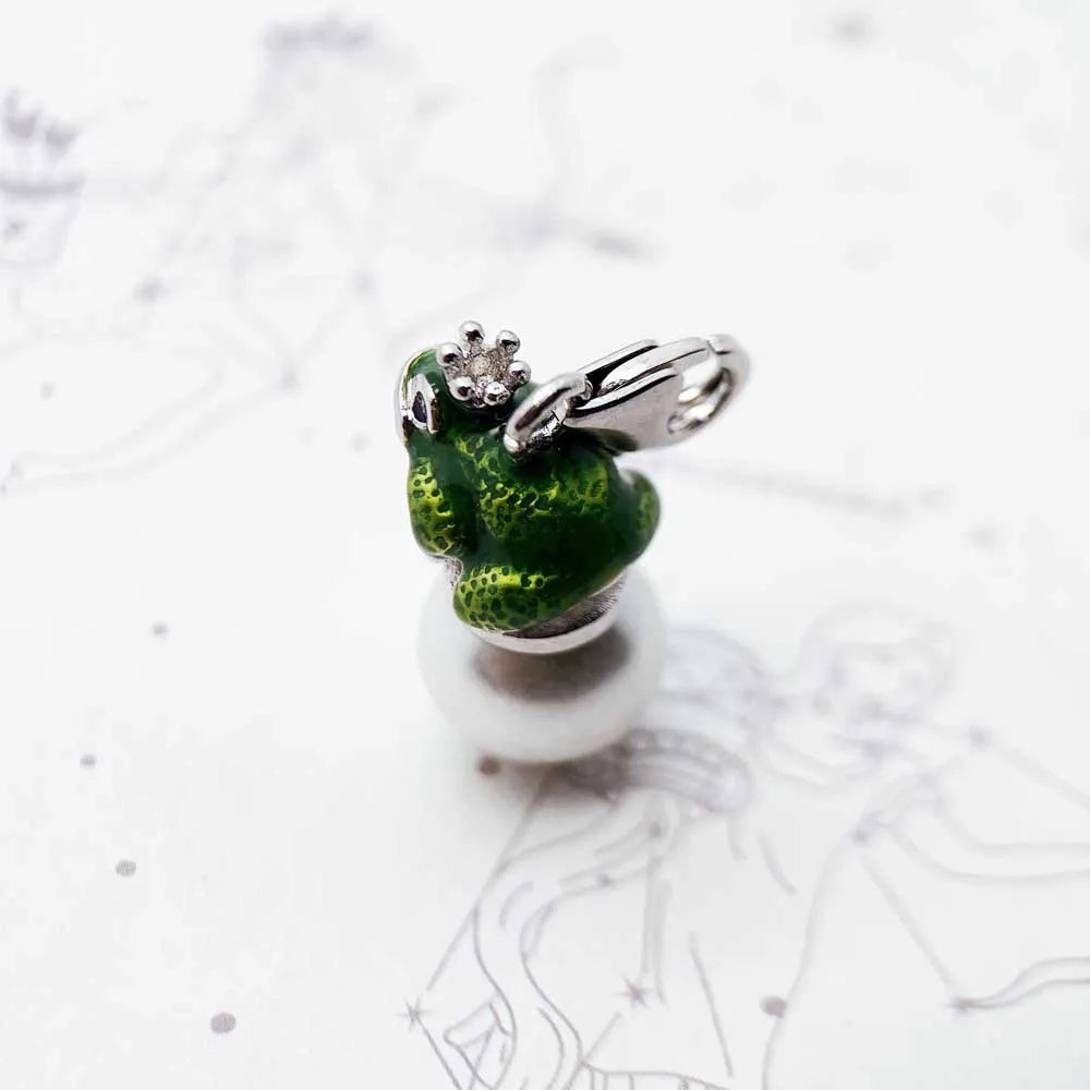 Green frog-shaped charm with a silver ring on a white background