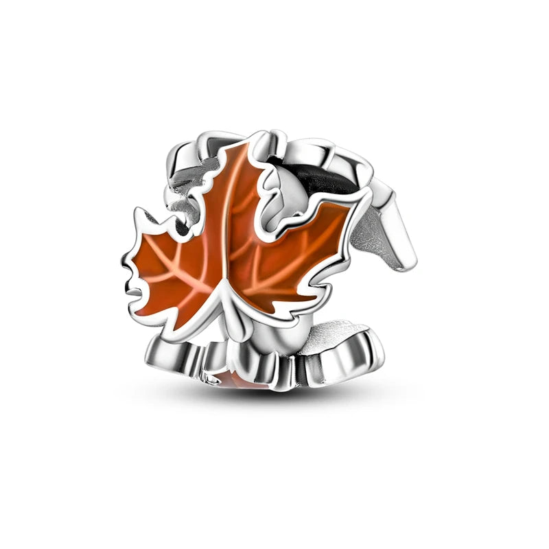 Silver charm with a red maple leaf on a white background