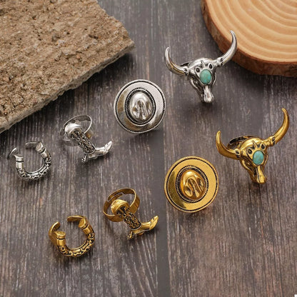Collection of decorative western charms or rings with cowboy designs on a wooden surface